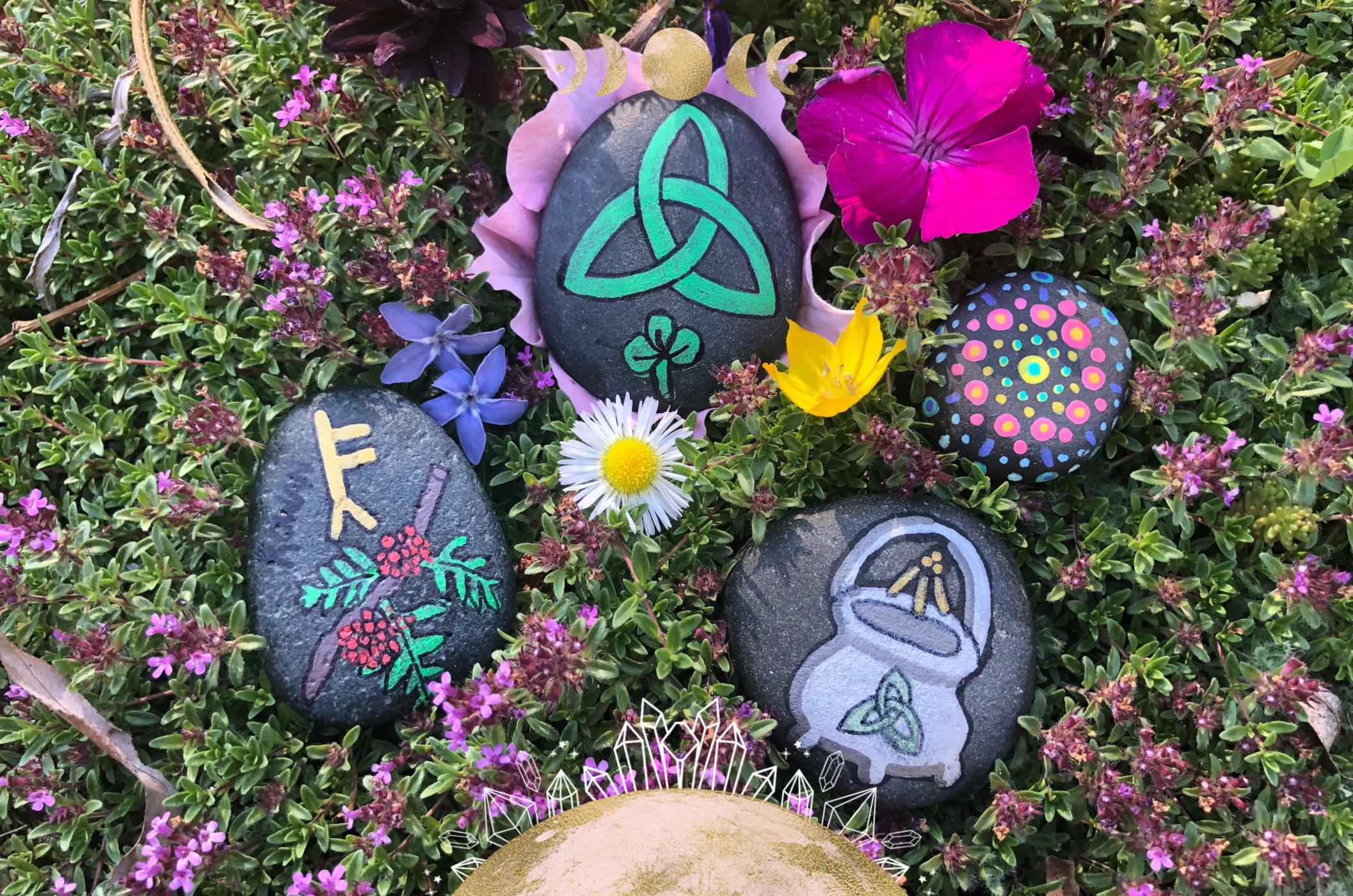 Image of painted stones surrounded by colorful flowers
