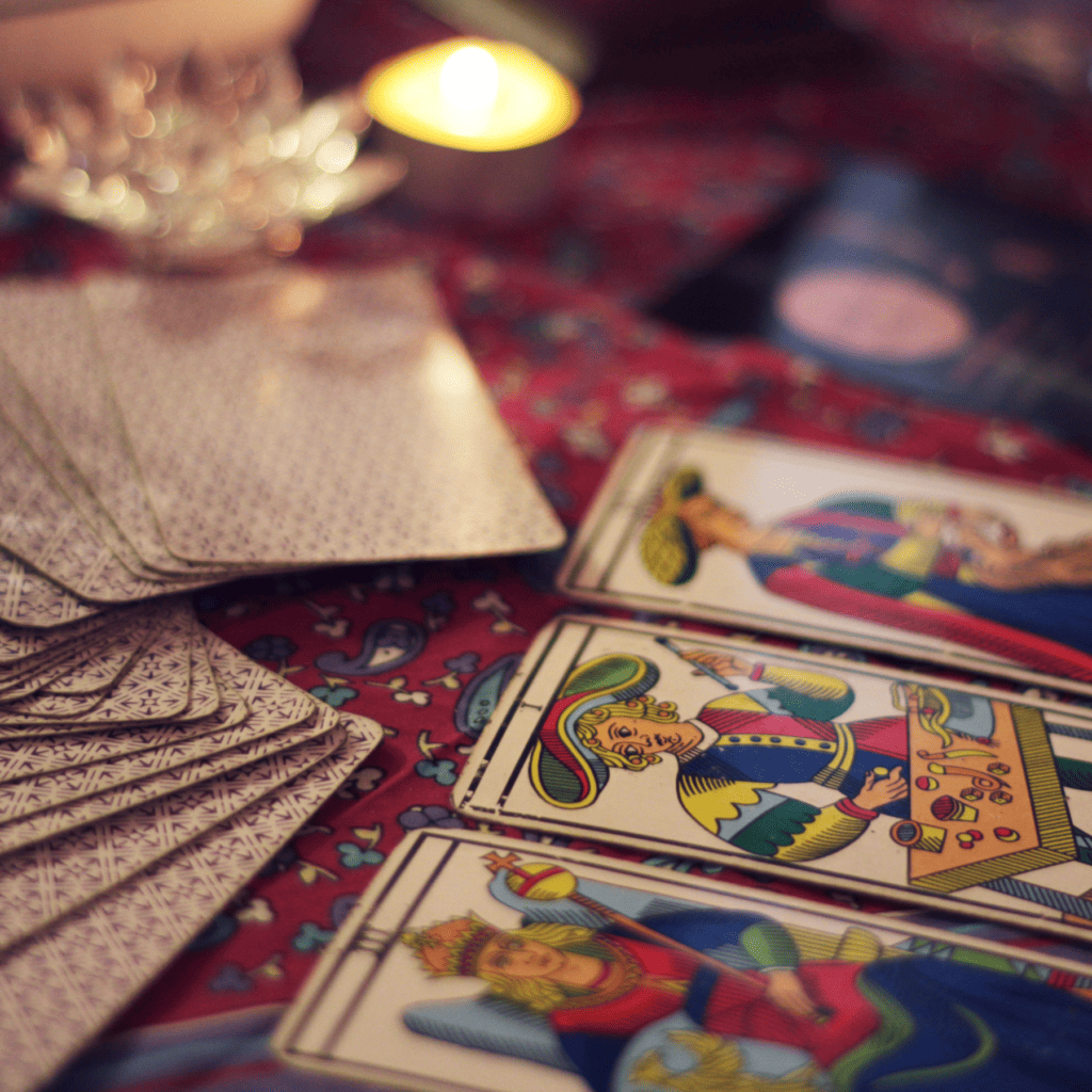 Tarot cards laying down on a red blanket in moody lighting