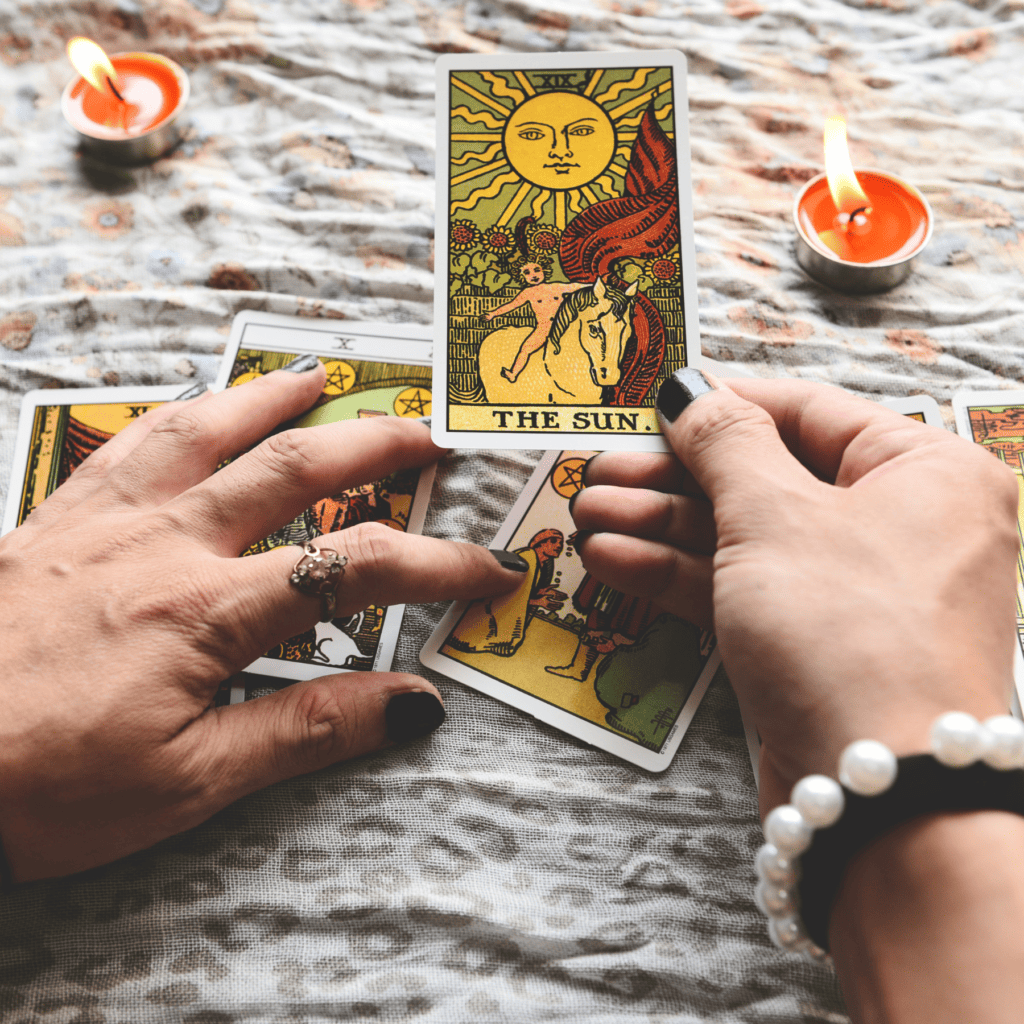 Hand holding a tarot card that says "The Sun"